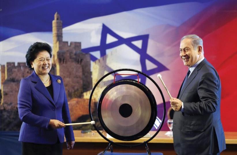 PRIME MINISTER Benjamin Netanyahu and Chinese Vice Premier Liu Yandong strike a gong at a joint news conference in Jerusalem last March. (photo credit: REUTERS)