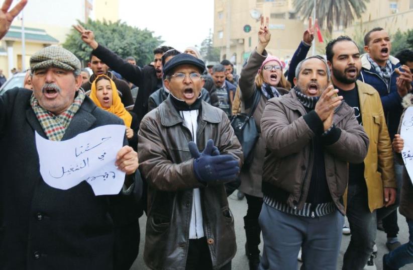 Unemployed protesters shout slogans during a demonstration demanding the government provide them with job opportunities, as Tunisia marks the sixth anniversary of the country’s 2011 revolution, in Sidi Bouzid, Tunisia, this month (photo credit: REUTERS)