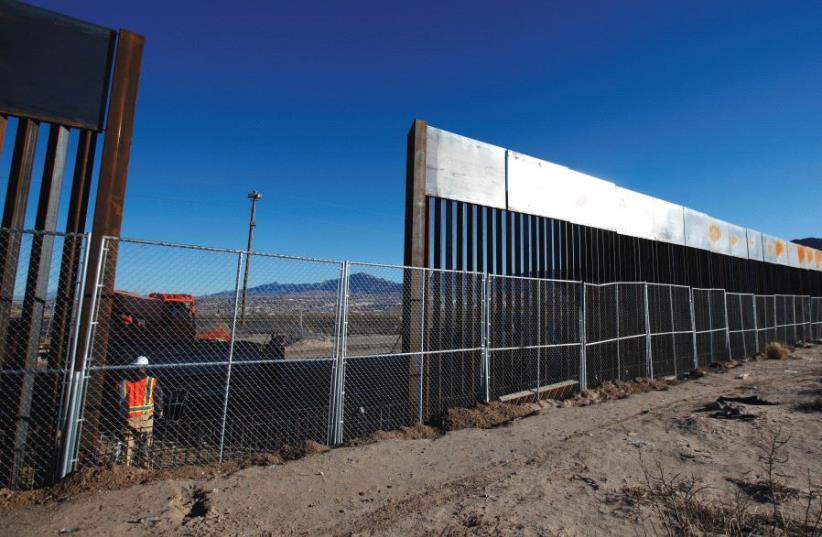 A WORKER STANDS next to a newly built section of the US border fence at Sunland Park, New Mexico, opposite the Mexican border city of Ciudad Juarez, on Wednesday. Picture taken from the Mexico side of the border. (photo credit: JOSE LUIS GONZALEZ/REUTERS)