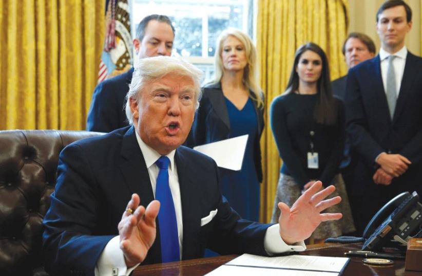 US PRESIDENT Donald Trump speaks to reporters while signing executive orders at the White House on Tuesday. (photo credit: KEVIN LAMARQUE/REUTERS)