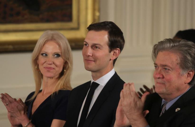 Senior staff at the White House Kellyanne Conway, Jared Kushner and Steve Bannon (L-R) applaud before being sworn in by Vice President Mike Pence in Washington, DC January 22, 2017. (photo credit: REUTERS)