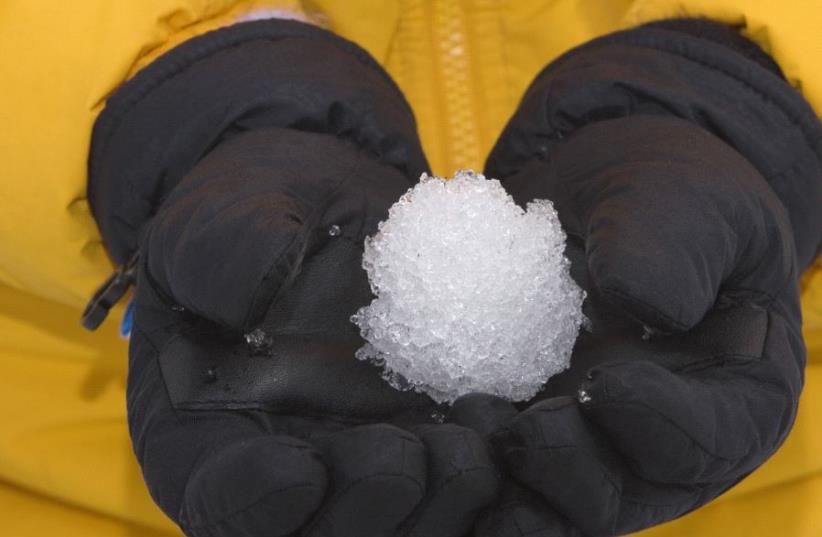 Person holding a snowball (illustrative) (photo credit: INGIMAGE)