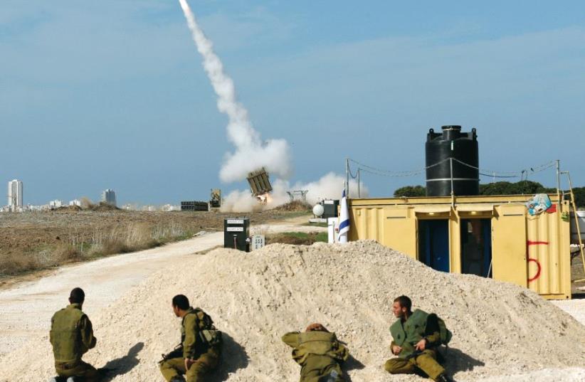 Israeli soldiers watch as an Iron Dome launcher fires an interceptor rocket near the southern city of Ashdod in 2012 (photo credit: REUTERS)