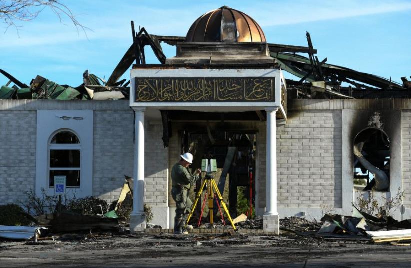A security official investigates the aftermath of a fire at the Victoria Islamic Center mosque in Victoria, Texas January 29, 2017.  (photo credit: REUTERS)