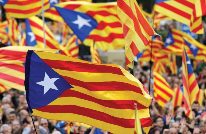 NOT JUST yet. People hold Catalan flags during a protest last year. (photo credit: REUTERS)
