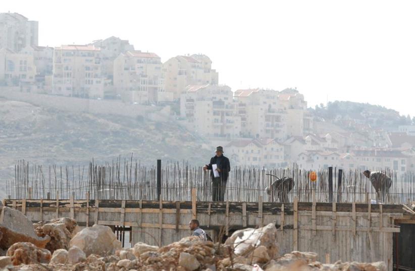 Palestinian labourers work at a construction site in Efrat (photo credit: REUTERS)