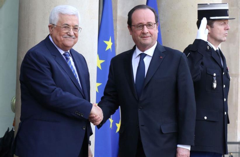 France's President Francois Hollande (R) welcomes Palestinian Authority President Mahmoud Abbas as he arrives for a meeting at the Elysee Palace in Paris, France, February 7, 2017 (photo credit: REUTERS)