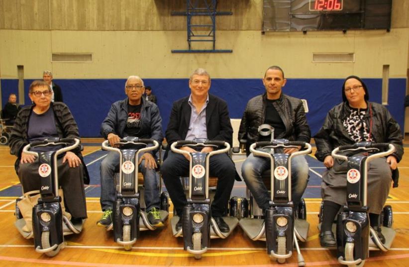 Disabled IDF veterans with their newly donated scooters (photo credit: GOLSAR PRODUCTION HOUSE)