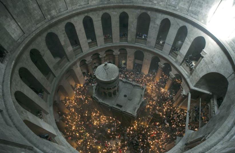 Worshipers hold candles as they take part in the Christian Orthodox Holy Fire ceremony at the Church of the Holy Sepulchre in Jerusalem’s Old City in April 2015 (photo credit: REUTERS)