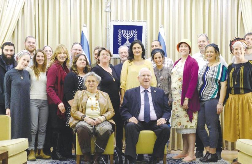 PRESIDENT REUVEN RIVLIN and his wife, Nechama, pose with members of the OneFamily community, whom they hosted at a Tu Bishvat Seder at his official residence in Jerusalem yesterday (photo credit: MARK NEYMAN/GPO)