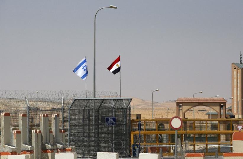 An Israeli flag (L) flutters next to an Egyptian one at the Nitzana crossing, along Israel's border with Egypt's Sinai desert (photo credit: REUTERS)