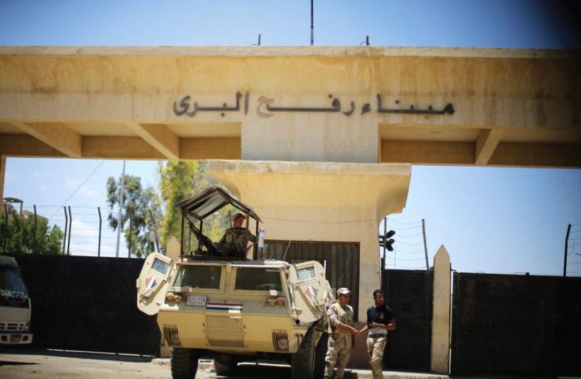 Egyptian soldiers stand guard in front of the Rafah border crossing between Egypt and the southern Gaza Strip (photo credit: REUTERS)
