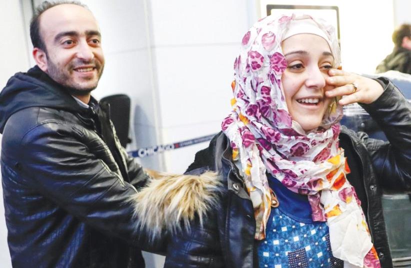 SYRIAN REFUGEES Baraa and her husband Abdulmajeed Haj Khalaf smile after arriving at O’Hare International Airport in Chicago, on Tuesday (photo credit: REUTERS)