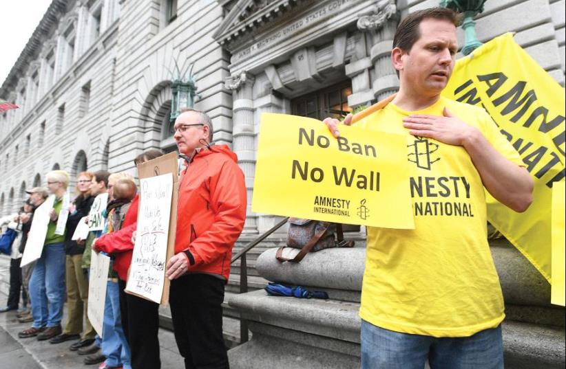 PROTESTERS LINE UP outside the 9th US Circuit Court of Appeals courthouse in San Francisco on Tuesday after the court heard arguments regarding President Donald Trump’s temporary travel ban on people from seven Muslim-majority countries. (photo credit: REUTERS)