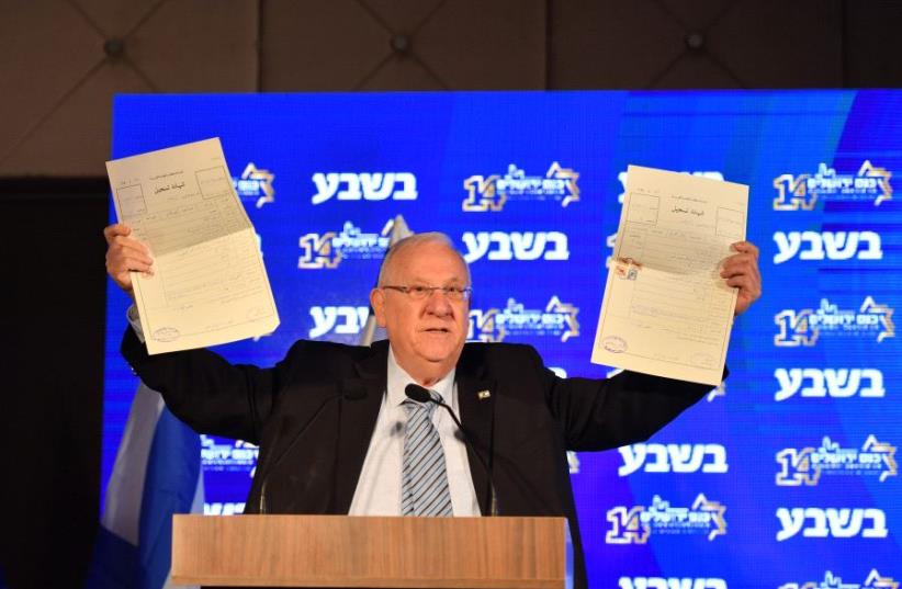 President Reuvin Rivlin holds land deeds he purchased from a Palestinian in the West Bank 40 years ago while speaking at the Jerusalem Conference (photo credit: YISRAEL BARDOGO)