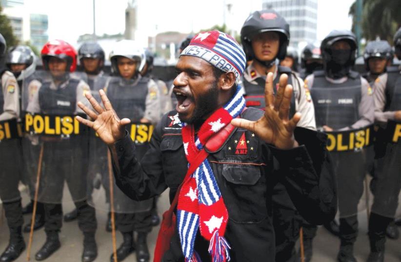 An activist shouts near a police line during a rally to commemorate the West Papuan declaration of independence (photo credit: REUTERS)