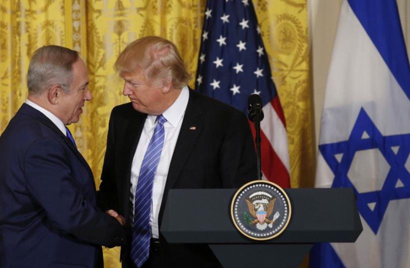 President Donald Trump (R) greets Israeli Prime Minister Benjamin Netanyahu at a joint news conference at the White House.  (photo credit: KEVIN LAMARQUE/REUTERS)