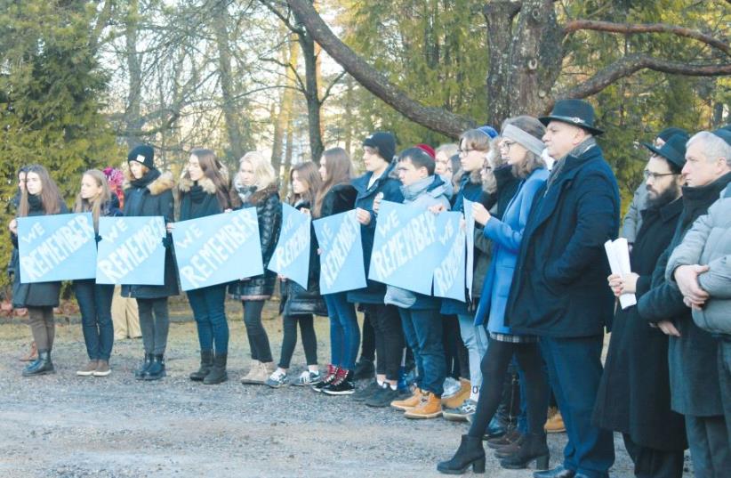 Jewish youth holding placards at the Tallinn cemetery. The rabbi of Estonia, Shmuel Kot, is second from the right (photo credit: BARRY DAVIS)