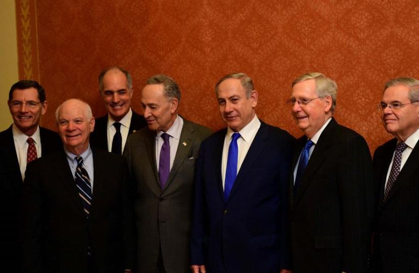 Netanyahu and US Congress members, including Senator Chuck Schumer next to the prime minister on the left (photo credit: AVI OHAYON - GPO)
