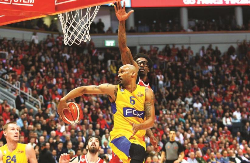 Maccabi Tel Aviv forward Devin Smith passes the ball behind both his and Amar’e Stoudemire’s back the State Cup final at the Jerusalem Arena on February 16, 2017 (photo credit: UDI ZITIAT)