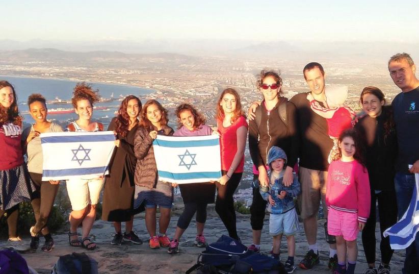 JEWISH AGENCY emissaries Aviad Sela (far right) and Hagai Dagan (holding the baby) pose for a photograph after a meeting of shlichim in Cape Town last year (photo credit: JAFI)