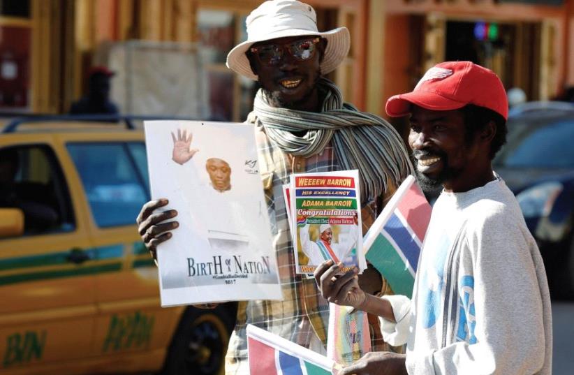 STREET SELLERS are seen with portraits of Gambia’s new president, Adama Barrow, in Serekunda, Gambia, last month (photo credit: REUTERS)