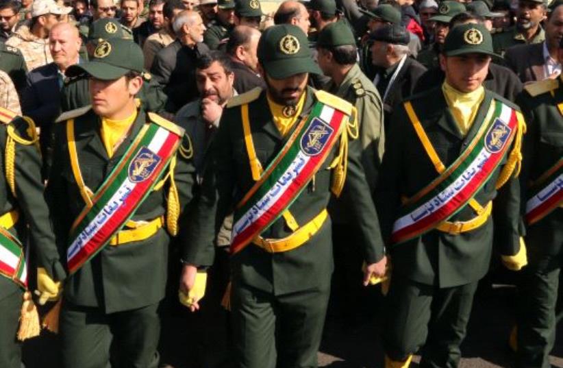 Iranian Revolutionary Guard members in Tehran carry the casket of Iran Revolutionary Guards Brigadier General Mohsen Ghajarian, who was killed in the northern province of Aleppo , Syria  (photo credit: ATTA KENARE / AFP)