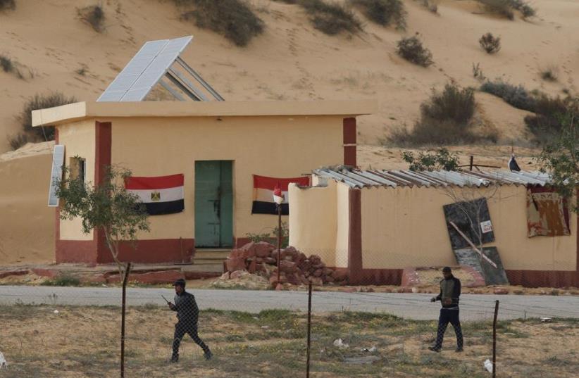 EGYPTIAN POLICEMEN are seen from the Israeli side patrolling the Sinai border on February 10. (photo credit: REUTERS)