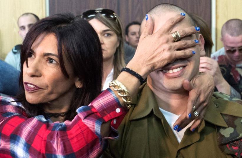  Elor Azaria is embraced by his mother as his father stands nearby, at the start of is sentencing hearing at a military court in Tel Aviv, Israel February 21, 2017 (photo credit: REUTERS)