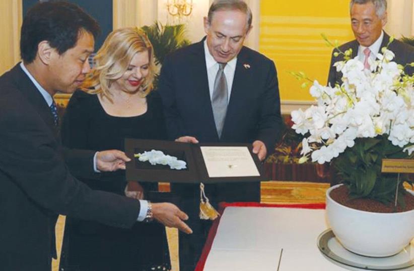 PRIME MINISTER Benjamin Netanyahu and his wife, Sara, with Singapore Prime Minister Lee Hsien Loong (second right) and his wife, Ho Ching, at the presidential palace in Singapore, where an orchid was named after the Netanyahus. (photo credit: CHAIM TZACH/GPO)