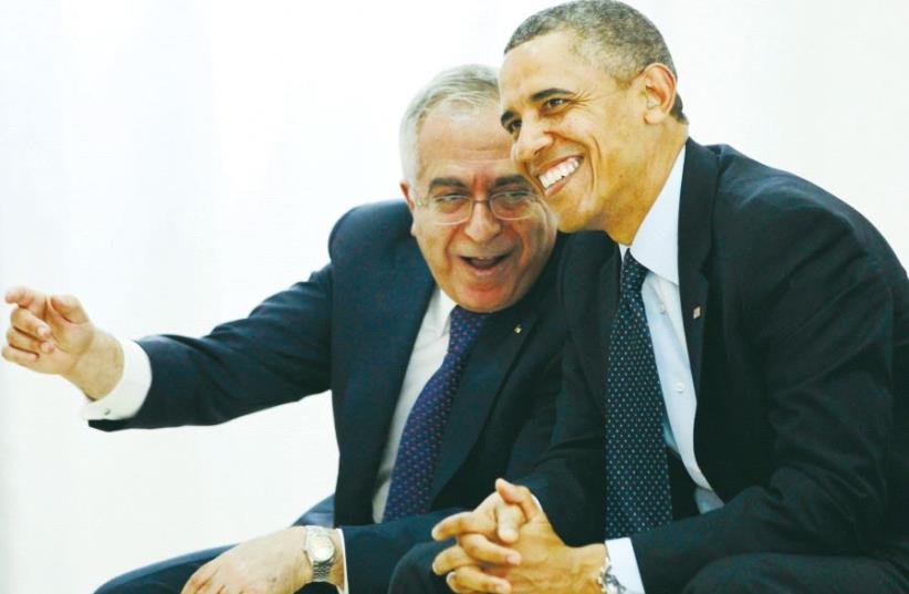 Then-US president Barack Obama watches a cultural event alongside then-Palestinian prime minister Salam Fayyad in Ramallah, 2013 (photo credit: REUTERS)