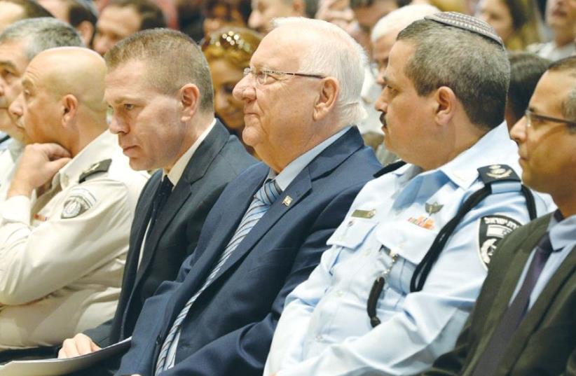 PRESIDENT REUVEN RIVLIN sits between Public Security Minister Gilad Erdan (left) and Police Commissioner Insp.-Gen. Roni Alsheich at a ceremony held at the President’s Residence in Jerusalem on Wednesday.  (photo credit: MARC NEYMAN/GPO)
