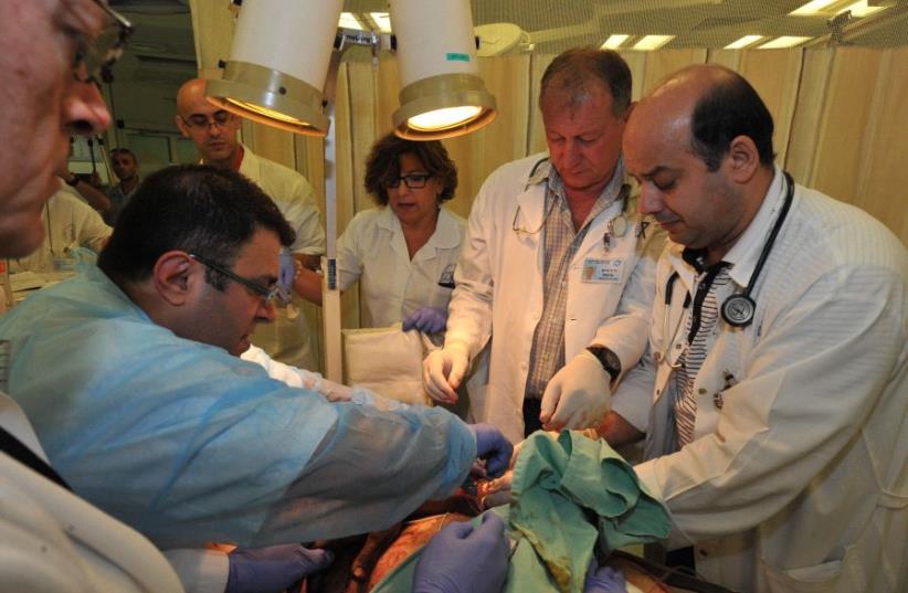 Doctors at the Western Galilee Medical Center treat wounded Syrians. (photo credit: WESTERN GALILEE MEDICAL CENTER)