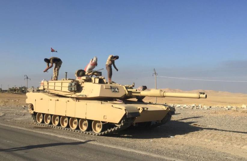 Iraqi armed forces stand on their US-made battle tank. As the army moves into western Mosul it will face stiffer resistance and its armored units will find difficulty maneuvering.  (photo credit: SETH J. FRANTZMAN)
