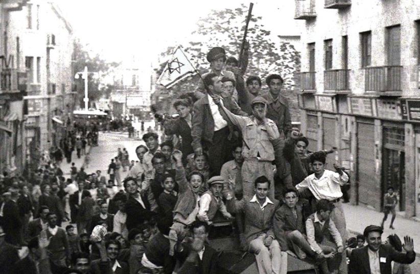 JEWS CROWD onto a British army armored car as they celebrate in downtown Jerusalem the morning after the United Nations voted to partition British mandate Palestine into a Jewish and an Arab state. (photo credit: REUTERS)