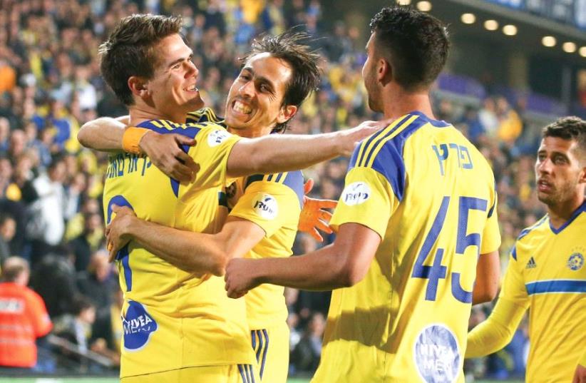 Vidar Orn Kjartansson (left) celebrates with teammates Yossi Benayoun (center) and Eliel Peretz after scoring the opener in last night’s 2-1 win over Maccabi Petah Tikva in the second leg of the State Cup quarterfinals (photo credit: DANNY MARON)