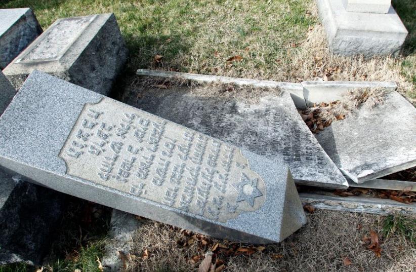 A headstone, pushed off its base by vandals, lays on the ground near a smashed tomb in the Mount Carmel Cemetery, a Jewish cemetery, in Philadelphia, Pennsylvania (photo credit: REPRODUCTION: RAANAN COHEN)