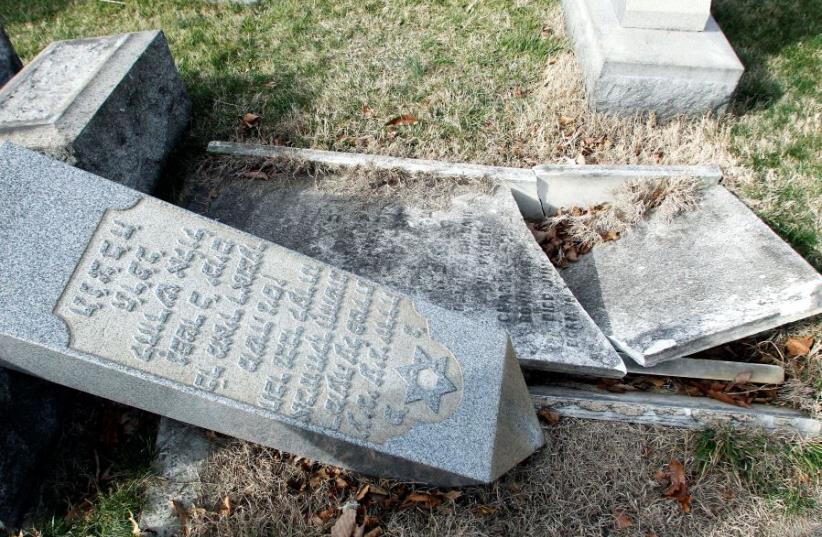 A headstone, pushed off its base by vandals, lays on the ground near a smashed tomb in the Mount Carmel Cemetery, a Jewish cemetery, in Philadelphia, Pennsylvania, US February 27, 2017. (photo credit: REUTERS)
