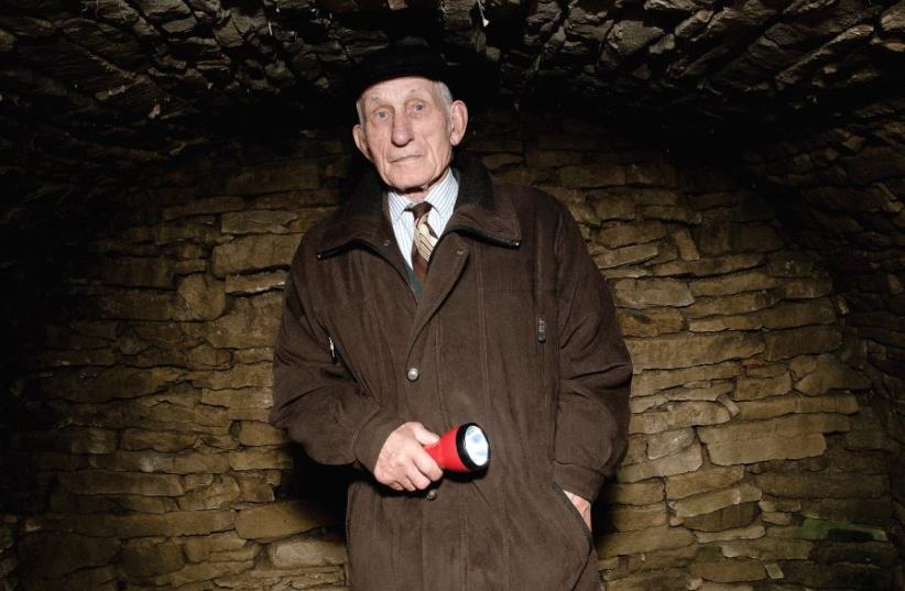 Jozef Jarosz inside the dugout where his family sheltered 14 Jews for almost two years during WWII (photo credit: PIOTR SADURSKI)