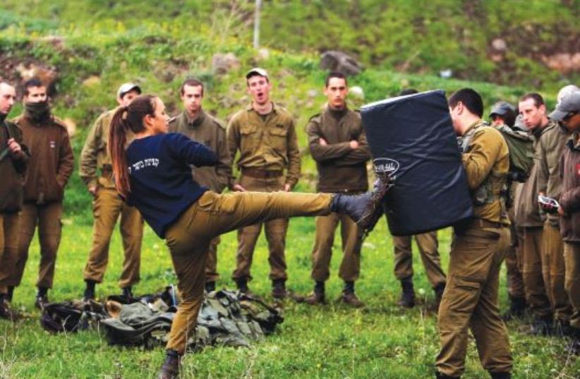 A FEMALE officer demonstrates a move a during a training session in Krav Maga, an Israeli self-defense technique, at a military base on the Golan Heights on March 1. (photo credit: REUTERS)