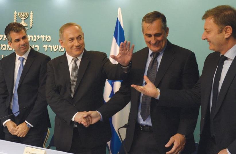 PRIME MINISTER Benjamin Netanyahu congratulates Intel CEO Brian Krzanich yesterday at his office on Intel’s acquisition of Mobileye, as (from left) Mobileye CTO Amnon Shashua, Economy Minister Eli Cohen and Mobileye president Ziv Aviram look on. (photo credit: CHAIM ZACH / GPO)