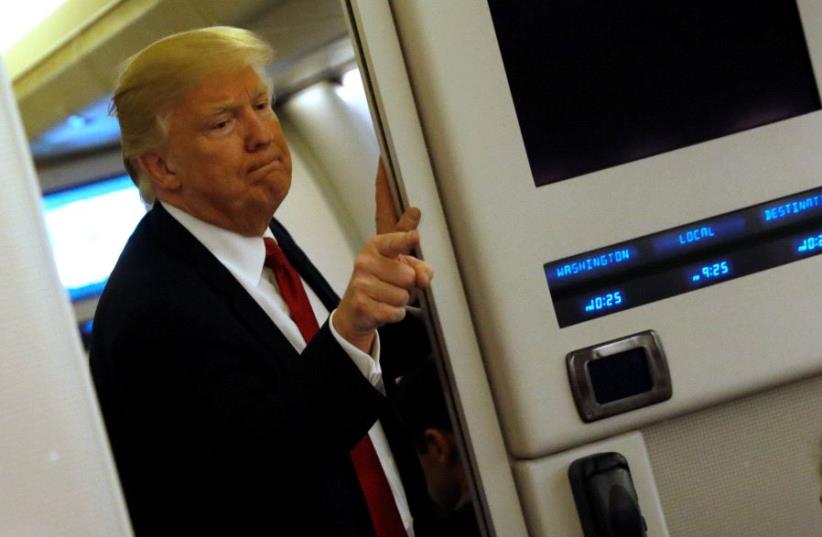 US President Donald Trump speaks to reporters aboard Air Force One (photo credit: REUTERS)