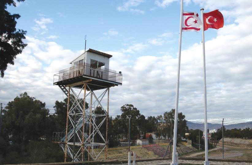 A UN guard post along the buffer zone of Cyprus and Northern Cyprus as a Turkish and Turkish-Cypriot flag wave nearby (photo credit: REUTERS)