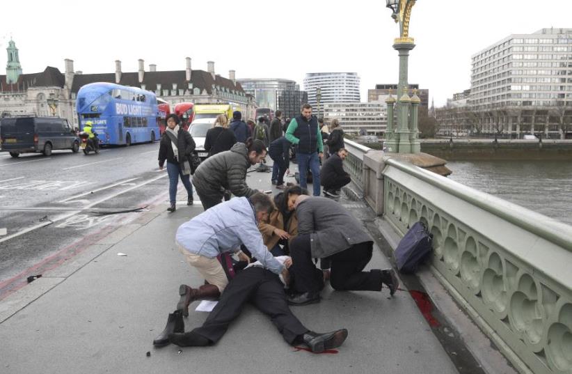 Injured people are assisted after an incident on Westminster Bridge in London, March 22, 2017.  (photo credit: REUTERS)