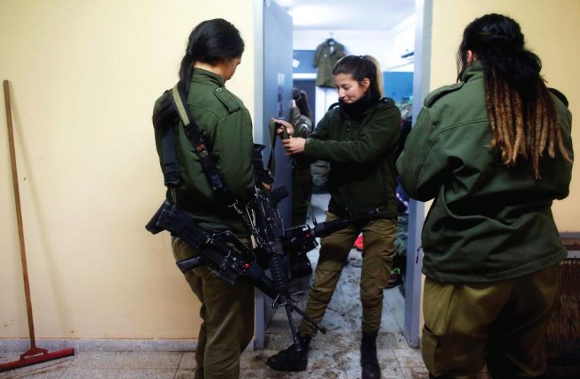 Female soldiers in an IDF artillery unit distribute weapons to their unit. (photo credit: REUTERS)