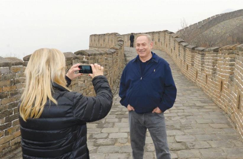 SARA NETANYAHU photographs her husband, Prime Minister Benjamin Netanyahu, at the Great Wall of China yesterday (photo credit: CHAIM ZACH / GPO)