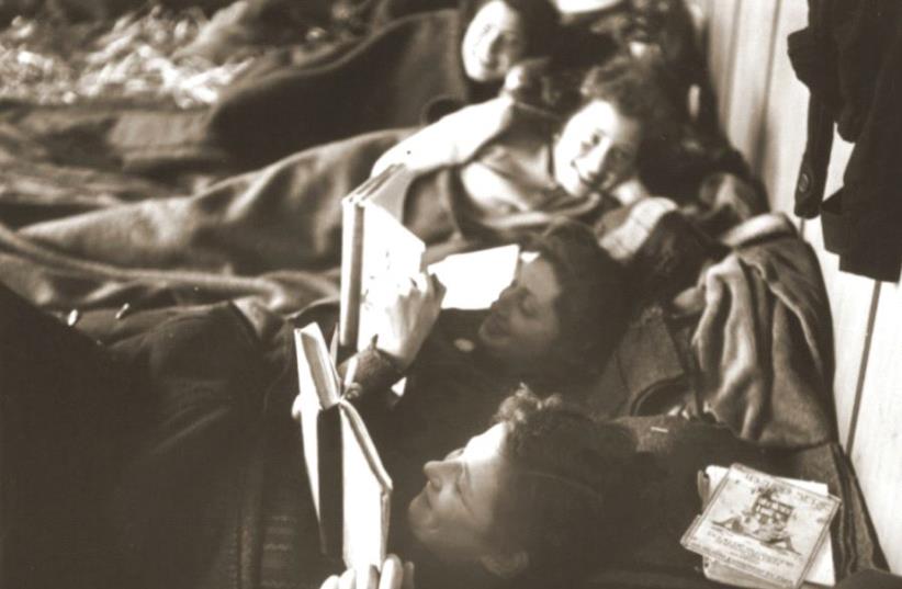 Jewish women rescued from Theresienstadt read while resting on their beds in the Hadwigschulhaus in St. Gallen, Switzerland (photo credit: WALTER SCHEIWILLER/UNITED STATES HOLOCAUST MEMORIAL MUSEUM)