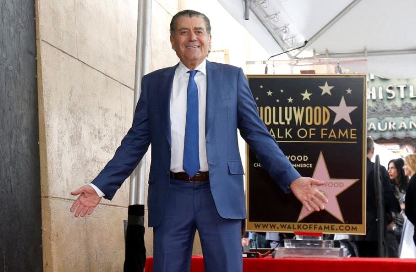 Israeli-American producer Haim Saban poses on his star after it was unveiled on the Hollywood Walk of Fame, March 22, 2017 (photo credit: REUTERS)