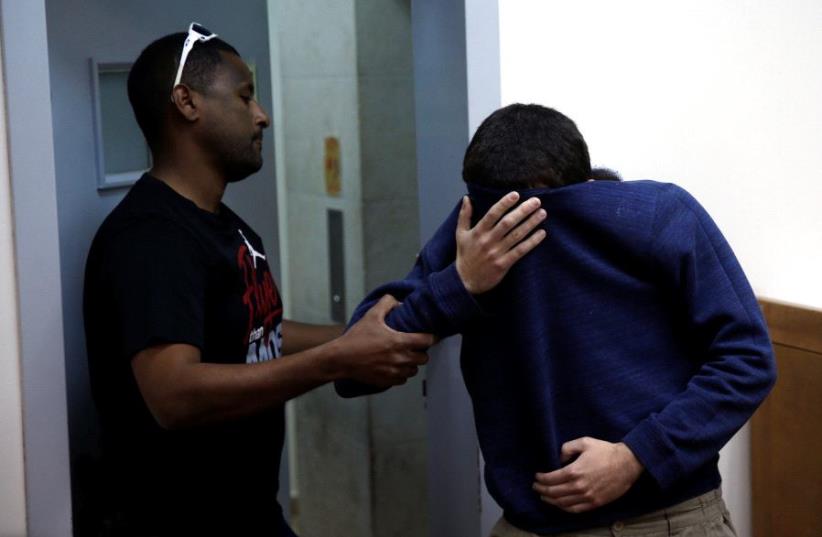 A US-Israeli teen who was arrested in Israel on suspicion of making bomb threats against Jewish community centers in the United States, Australia and New Zealand over the past three months, is seen before the start of a remand hearing at Magistrate's Court in Rishon Lezion, Israel March 23, 2017.  (photo credit: REUTERS)