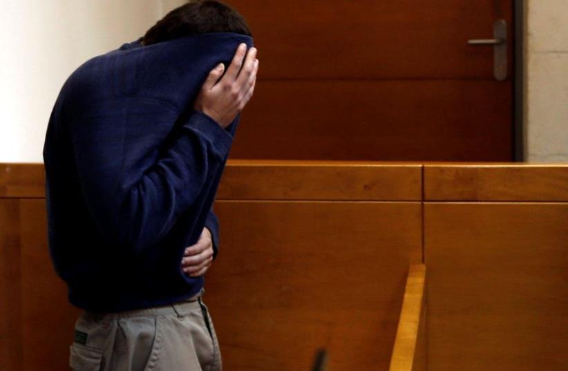 An US-Israeli teen who was arrested in Israel on suspicion of making bomb threats against Jewish community centers in the United States, Australia and New Zealand over the past three month, is seen before the start of a remand hearing at Magistrate's Court in Rishon Lezion, Israel March 23, 2017. (photo credit: REUTERS)